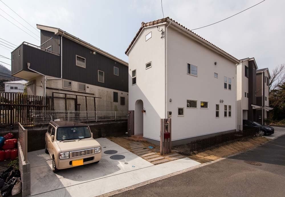 枕木アプローチとアール壁の玄関が印象的な外観